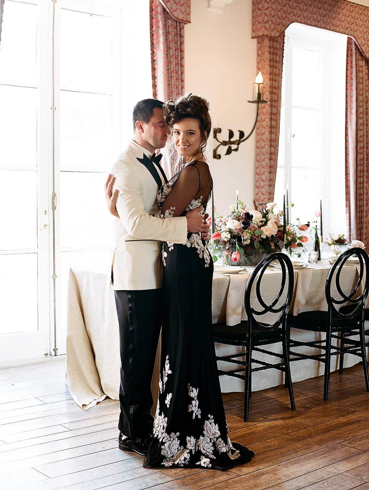 Bride and groom embracing and standing next to wedding reception table