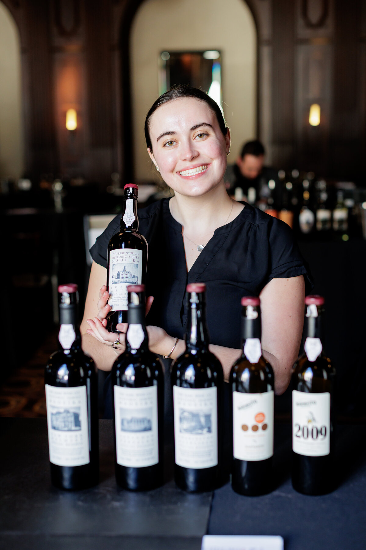 Female smiling holding a bottle of wine
