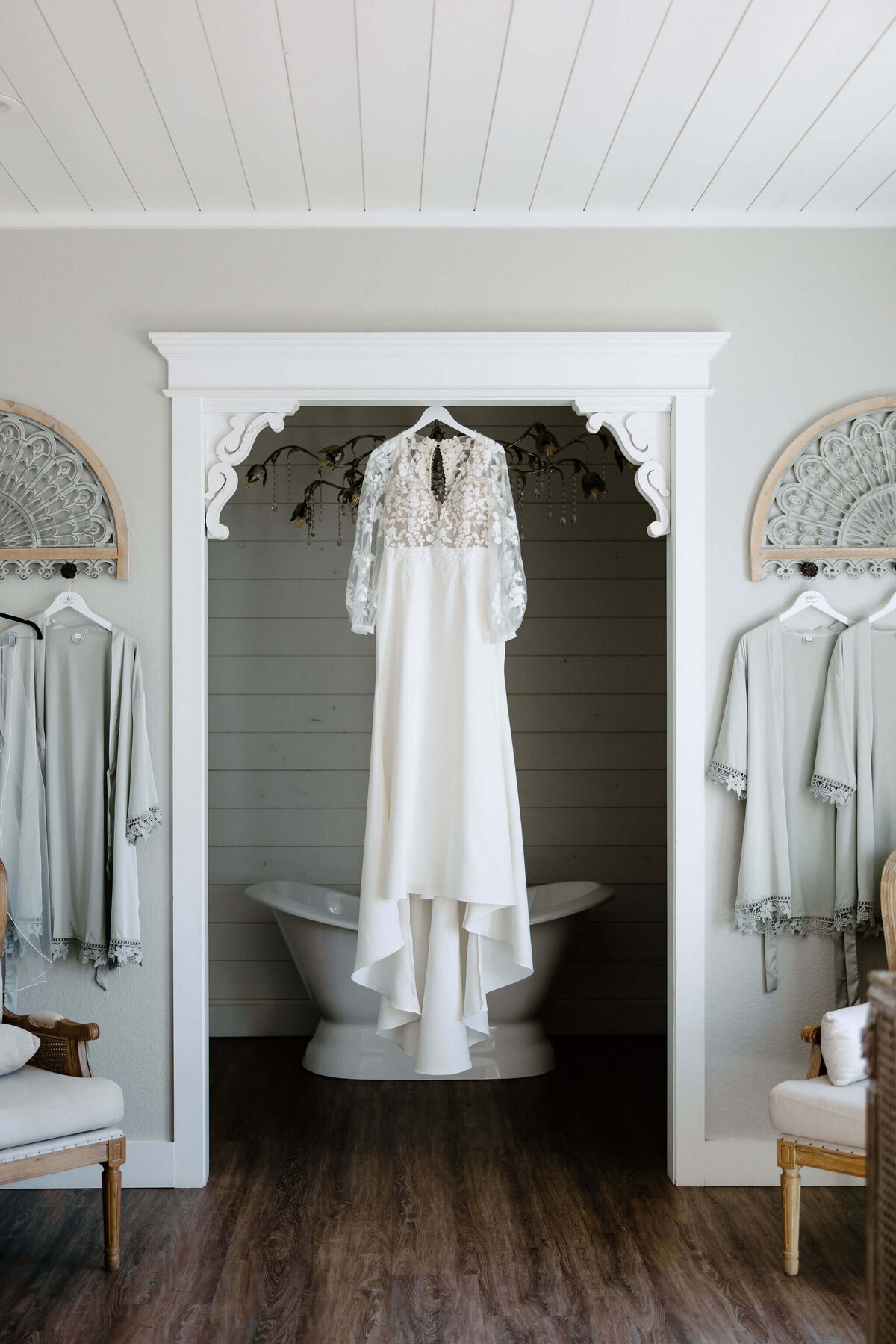 Vintage lace wedding gown hanging from door frame of bridal sweet at Chandelier Farms wedding venue in Terrell, Texas