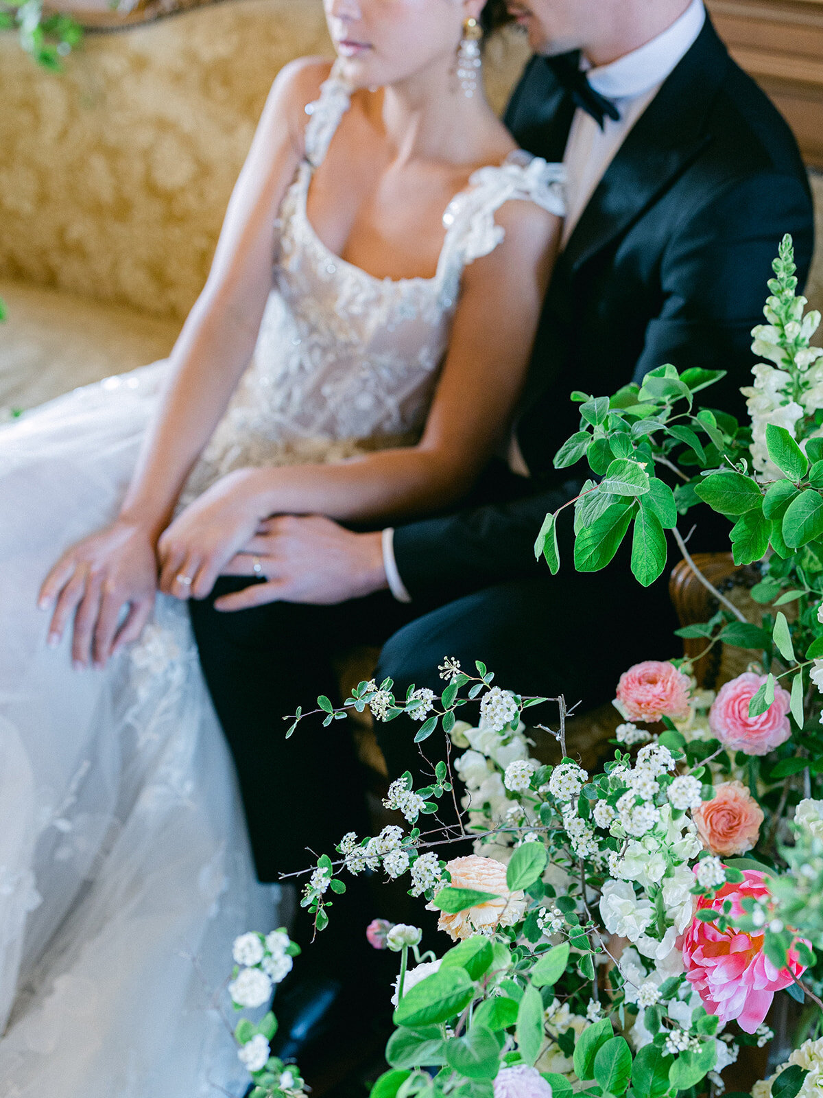 les mariés sur un sofa entouré de fleurs