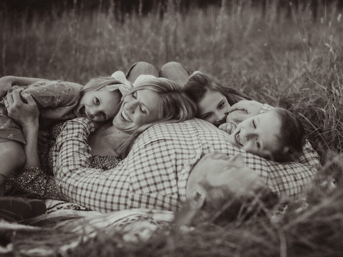 A family laying in a pile on a blanket at The Vine Photography Venue. 