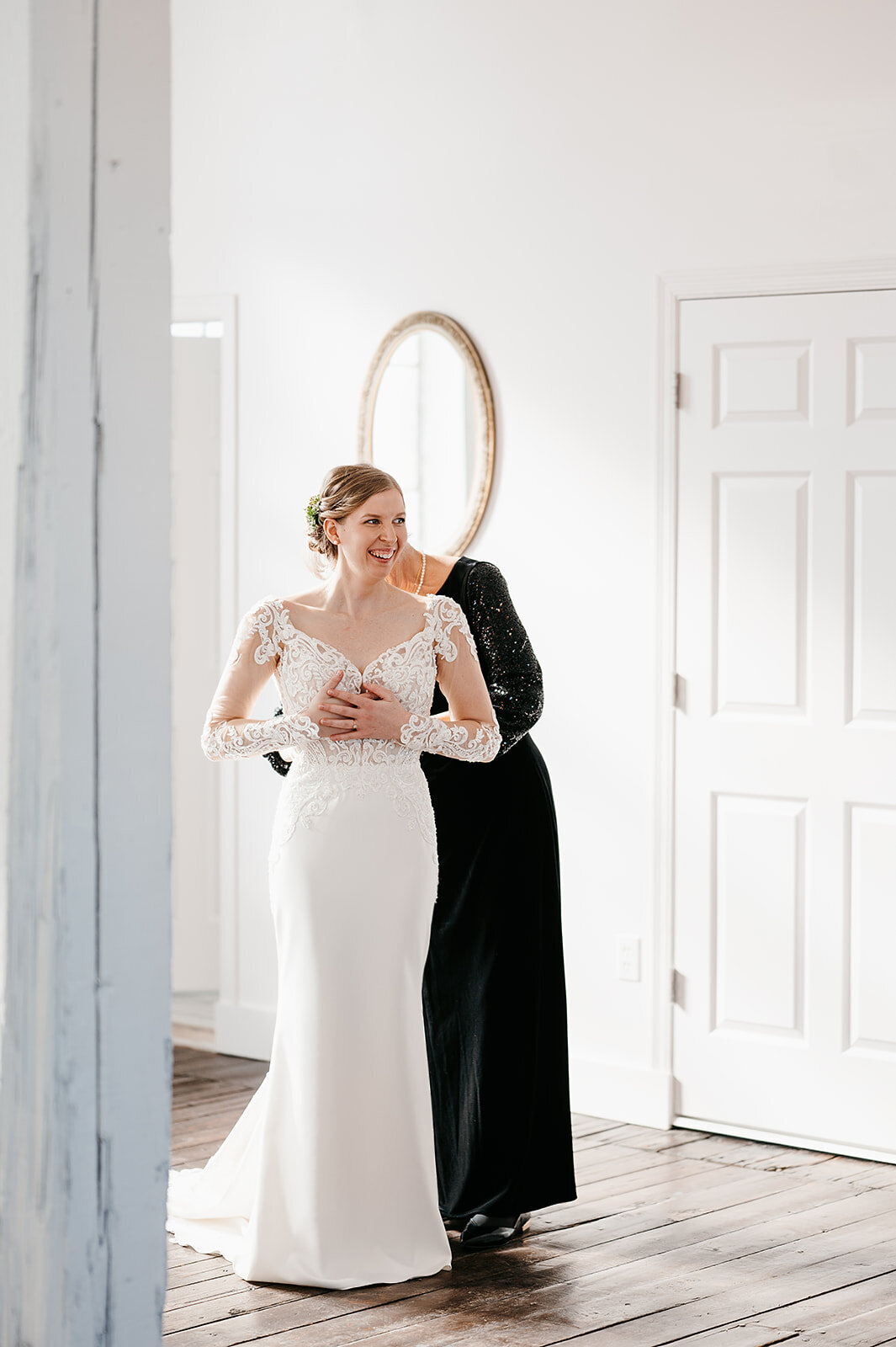 Mom helps bride get into dress in bridal suite and Norther Pacific Center in Northern Minnesota