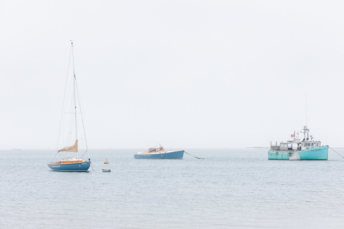 Three boats anchored in calm, misty harbor waters under a pale gray sky off Chatham Bars Inn in Chatham, Massachusetts — representing the portfolio of a Cape Cod engagement photographer.
