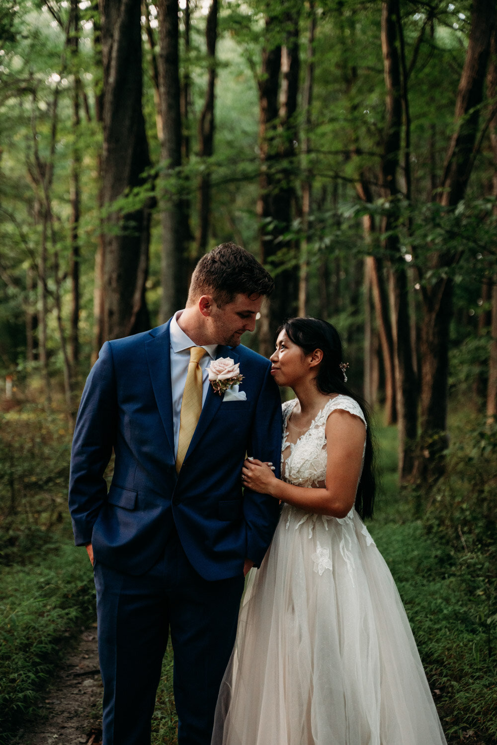 Two people elope at Mohican Treehouse and stand in woods