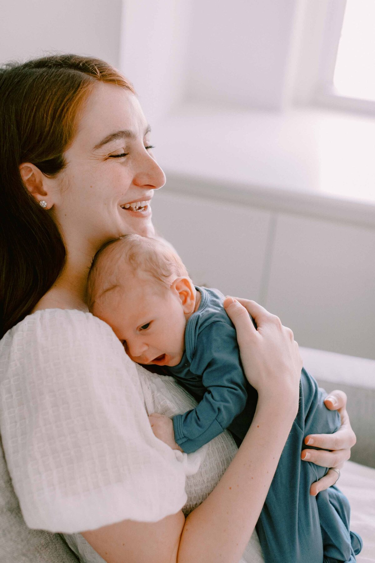 mom smiling while she holds her new baby