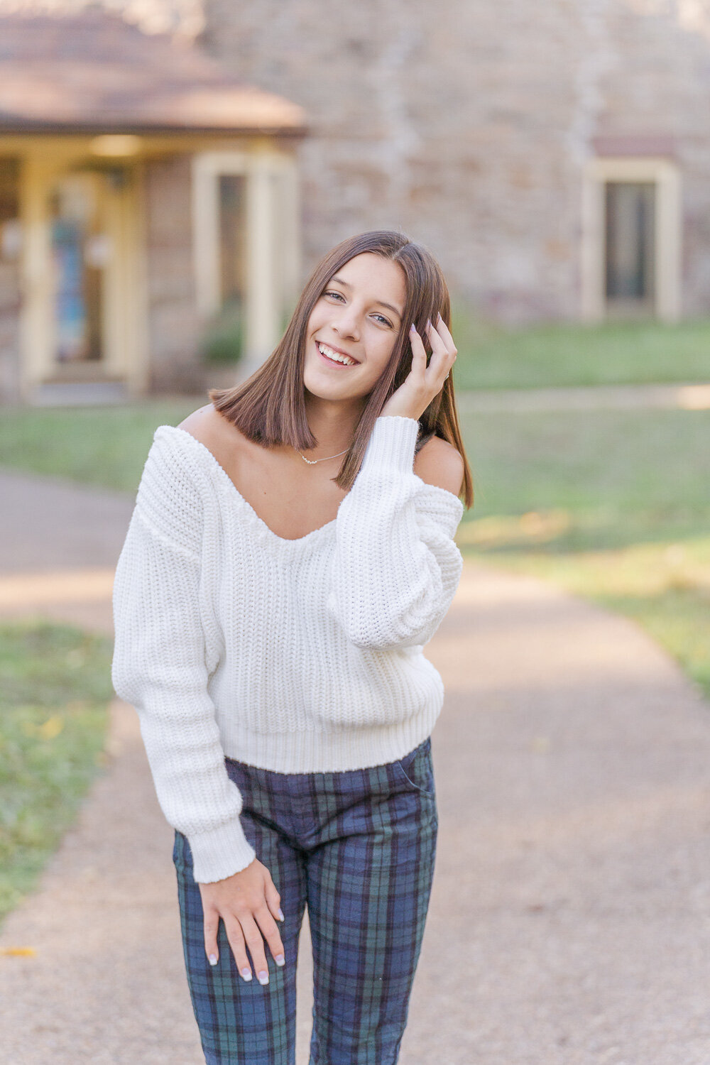 girl laughing while fixing hair during senior session in Alexandria, Virginia