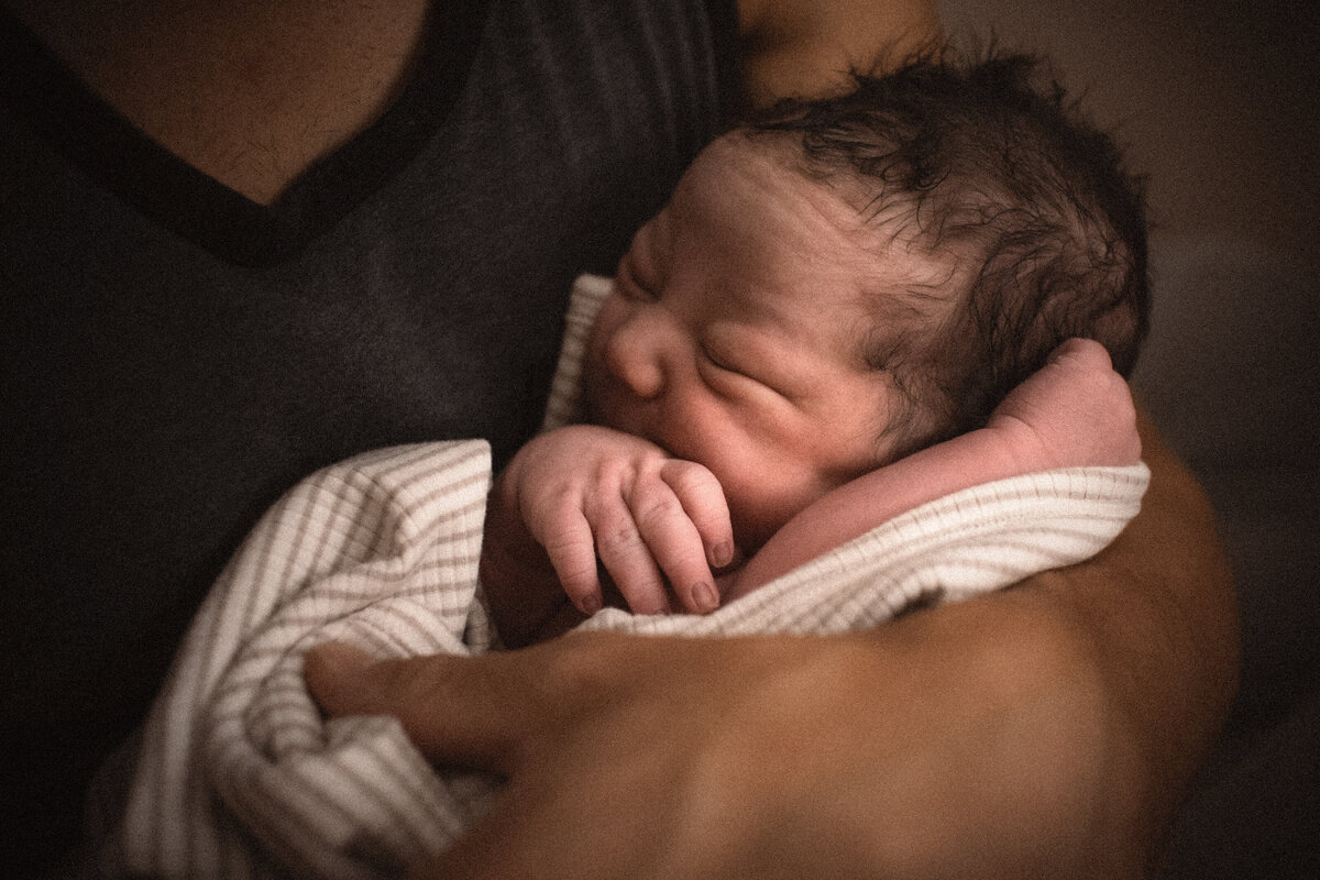 Homebirth father holding newborn baby