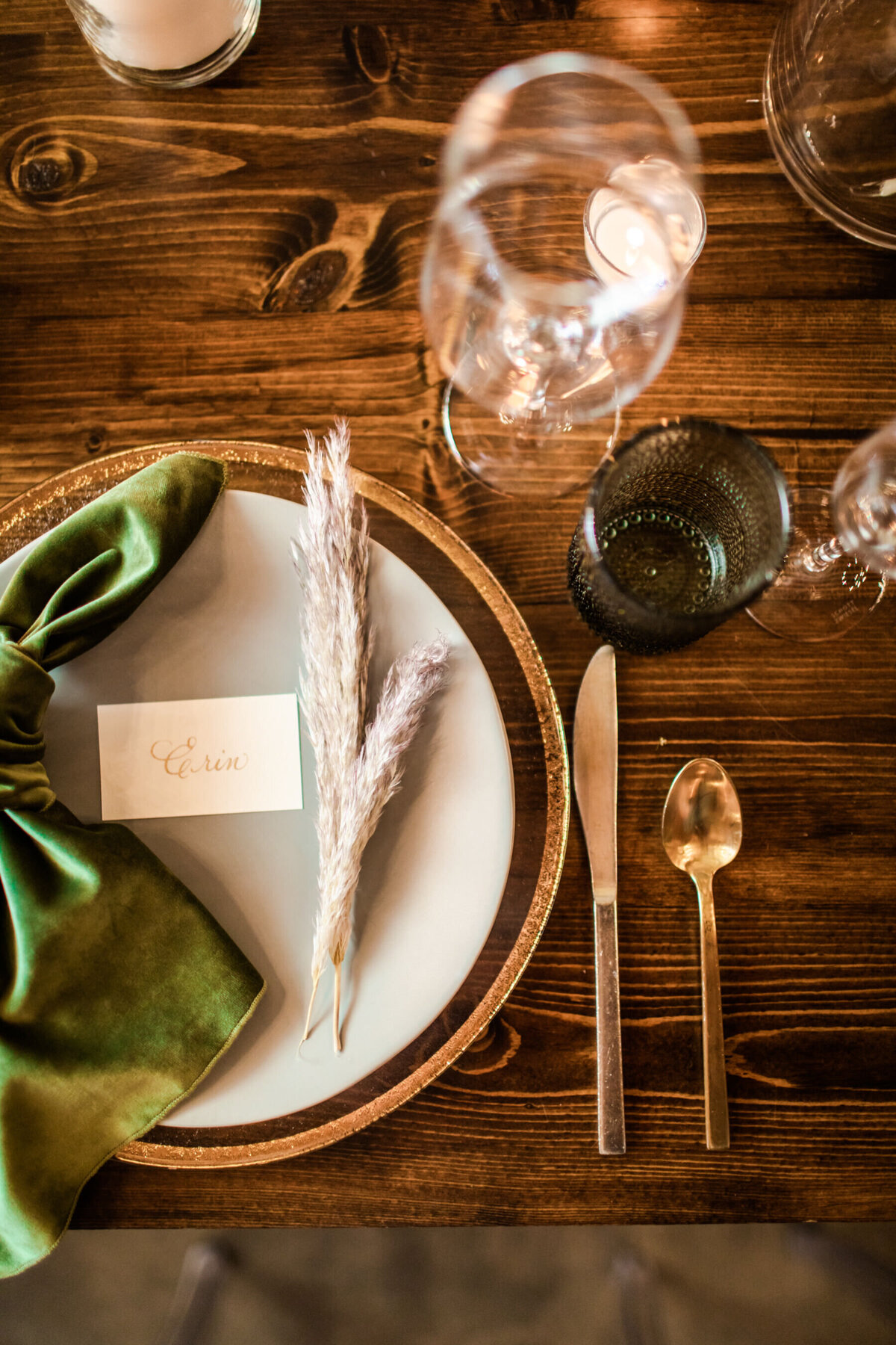 guest place setting with a swig of pampas grass and green velvet napkin