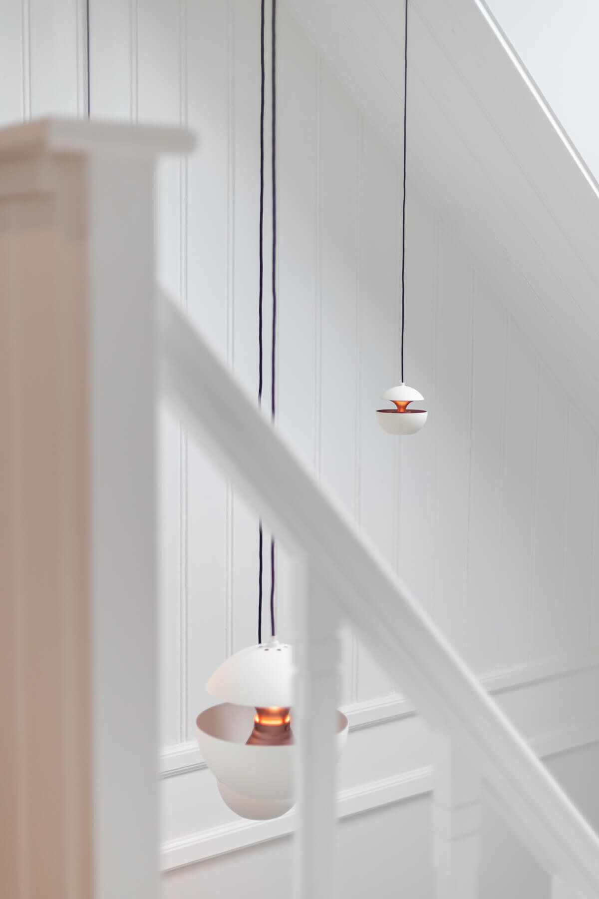 witte ronde hanglampen in trappenhuis