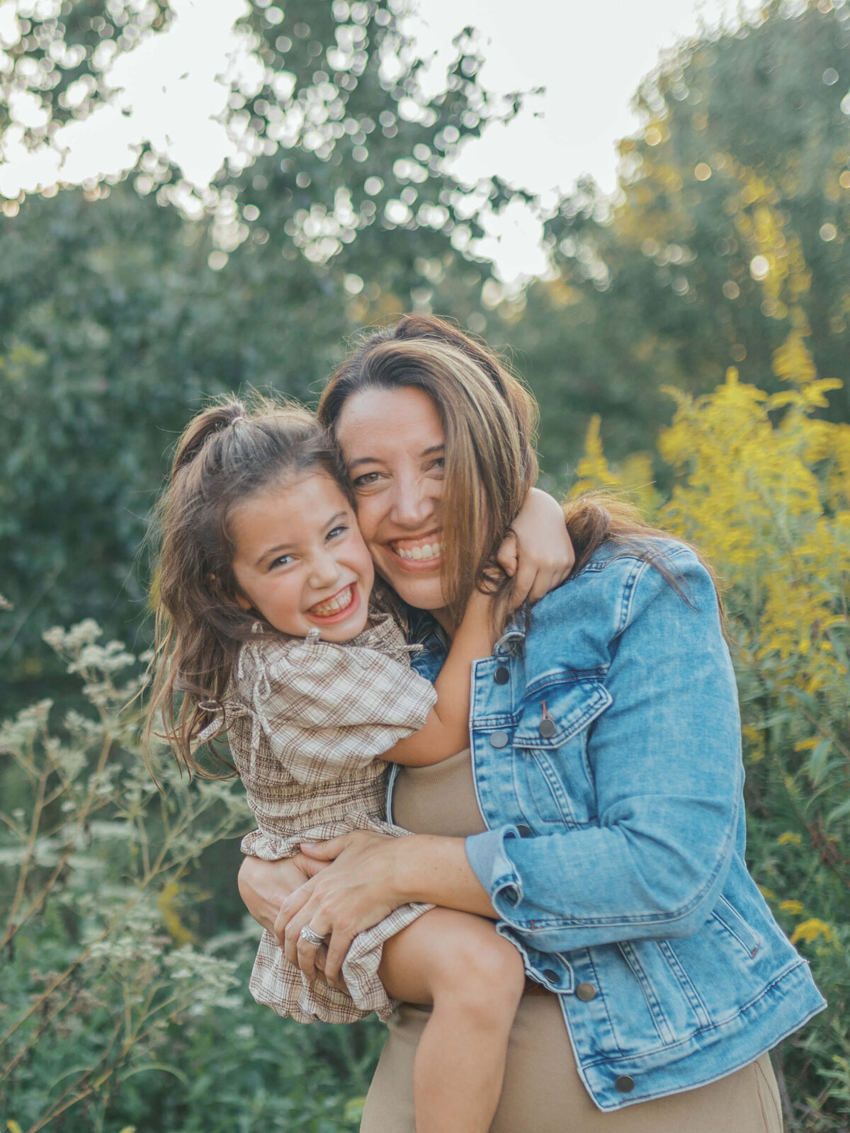 Mom and daughter sharing laughter and a sweet moment together at sunset during their photo session at Garrard Landing Park in Alpharetta, Georgia. Captured in warm evening light by Denay Shook Photography, highlighting genuine connection and emotion.