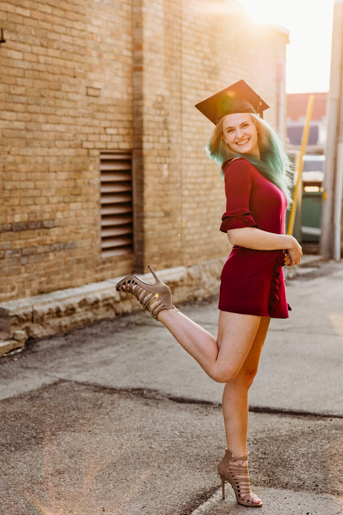 Kimberly High School graduate posing in an alley for cap and gown session