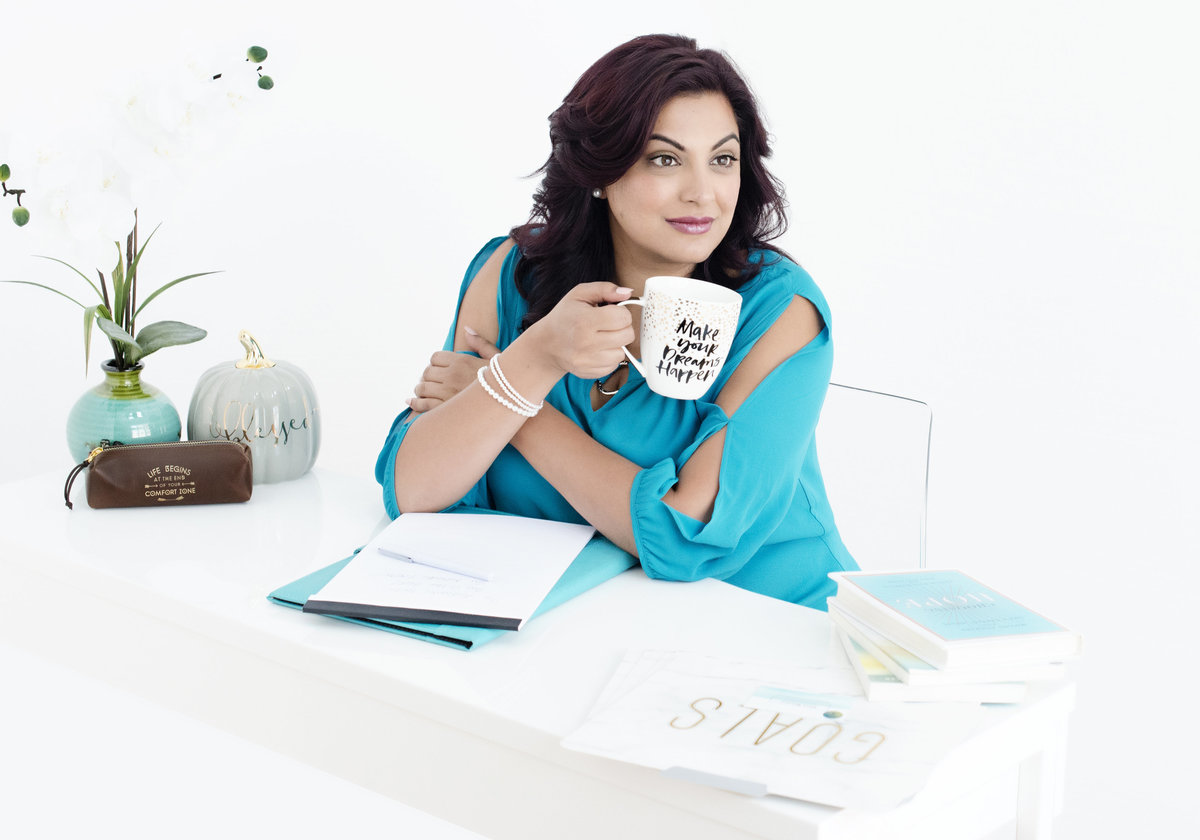 personal brand photography  for  success coach from  Oakville ontraio sitting on her work desk sipping coffee from her  cup  and  writting in her  journal