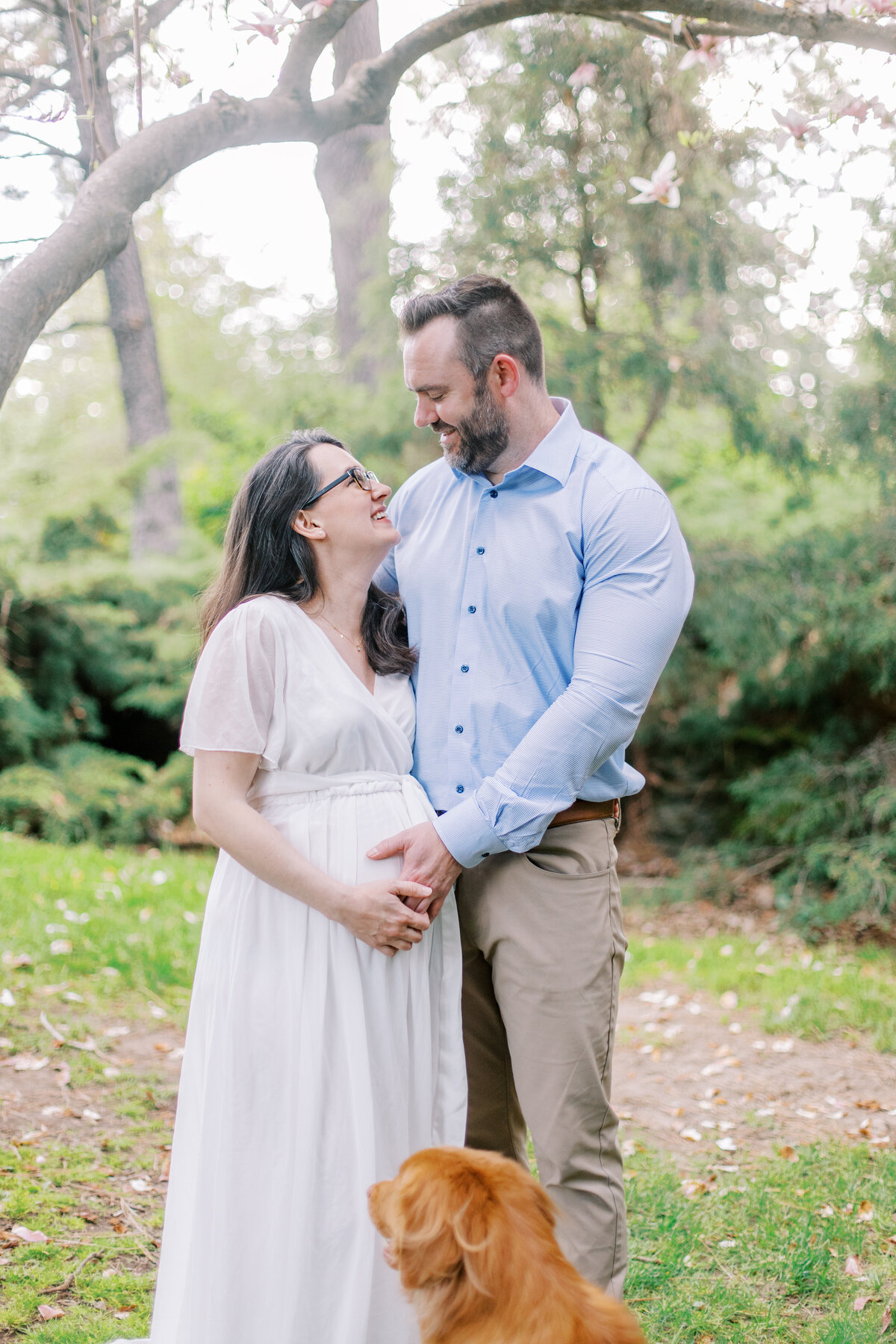 couple looking at each other and dog looking at them taken by maternity photographers spokane