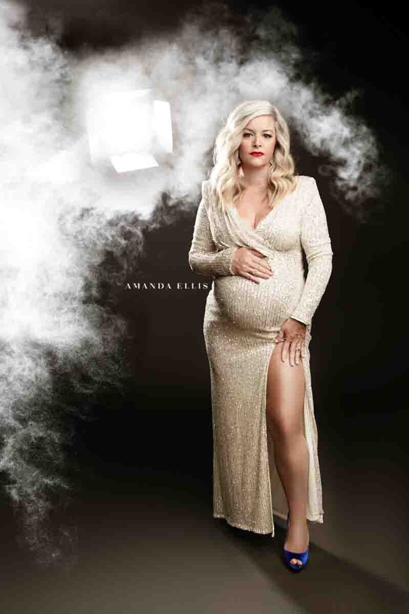 Artistic maternity portrait of woman  with smoke in the background