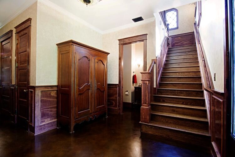 grand wooden staircase in custom home. strong wooden banister for large staircase in home.
