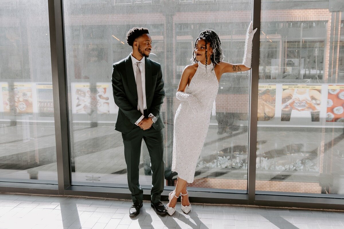 Bride and groom standing on a glass wall