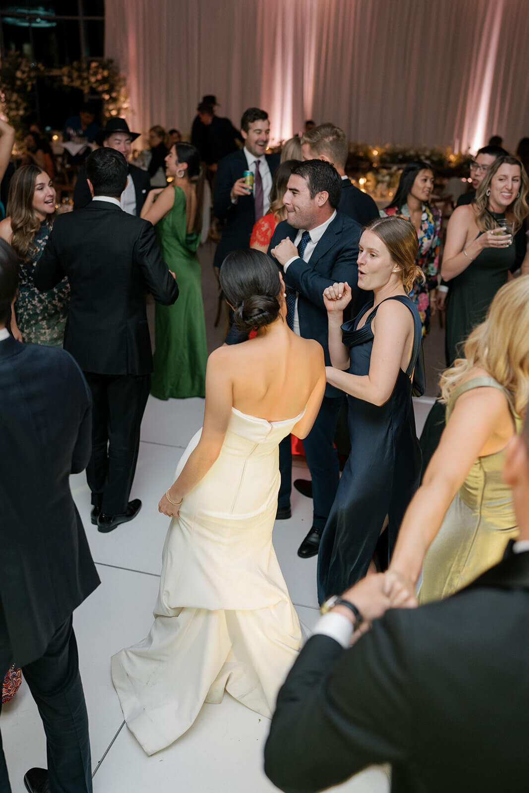 The bride dances in the middle of the dancefloor among her friends and family at her Aspen Meadows Resort wedding reception.