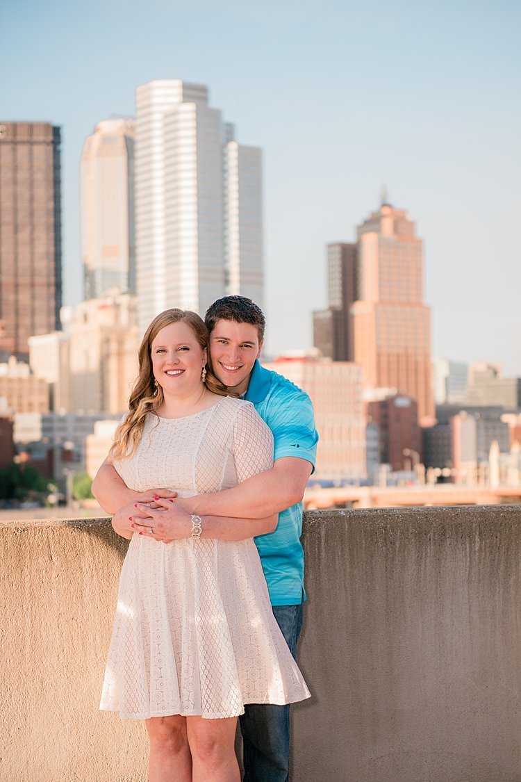 Engaged couple on top of parking garage with city of Pittsburgh, PA in the background