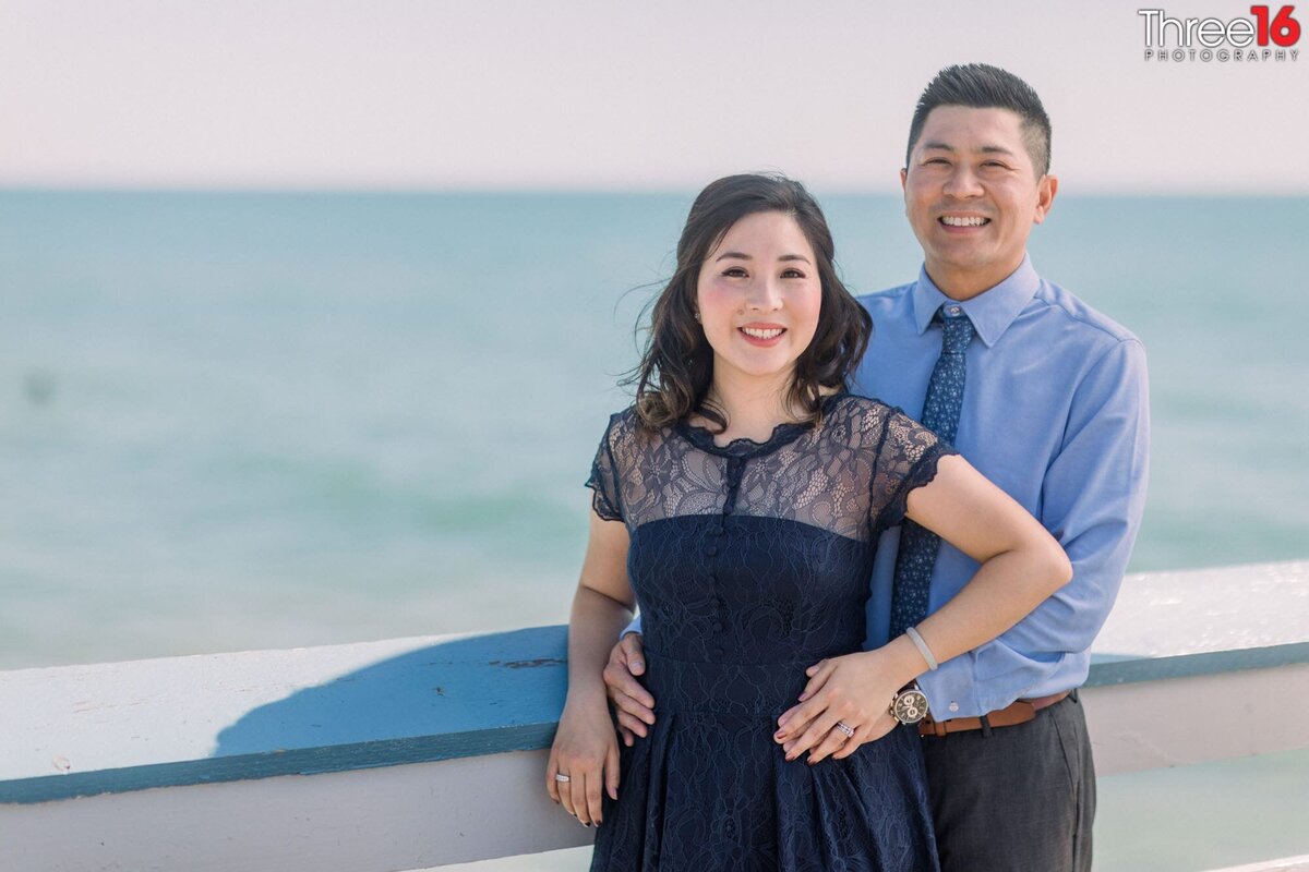 Beautiful pose of engaged couple with the Pacific Ocean behind them