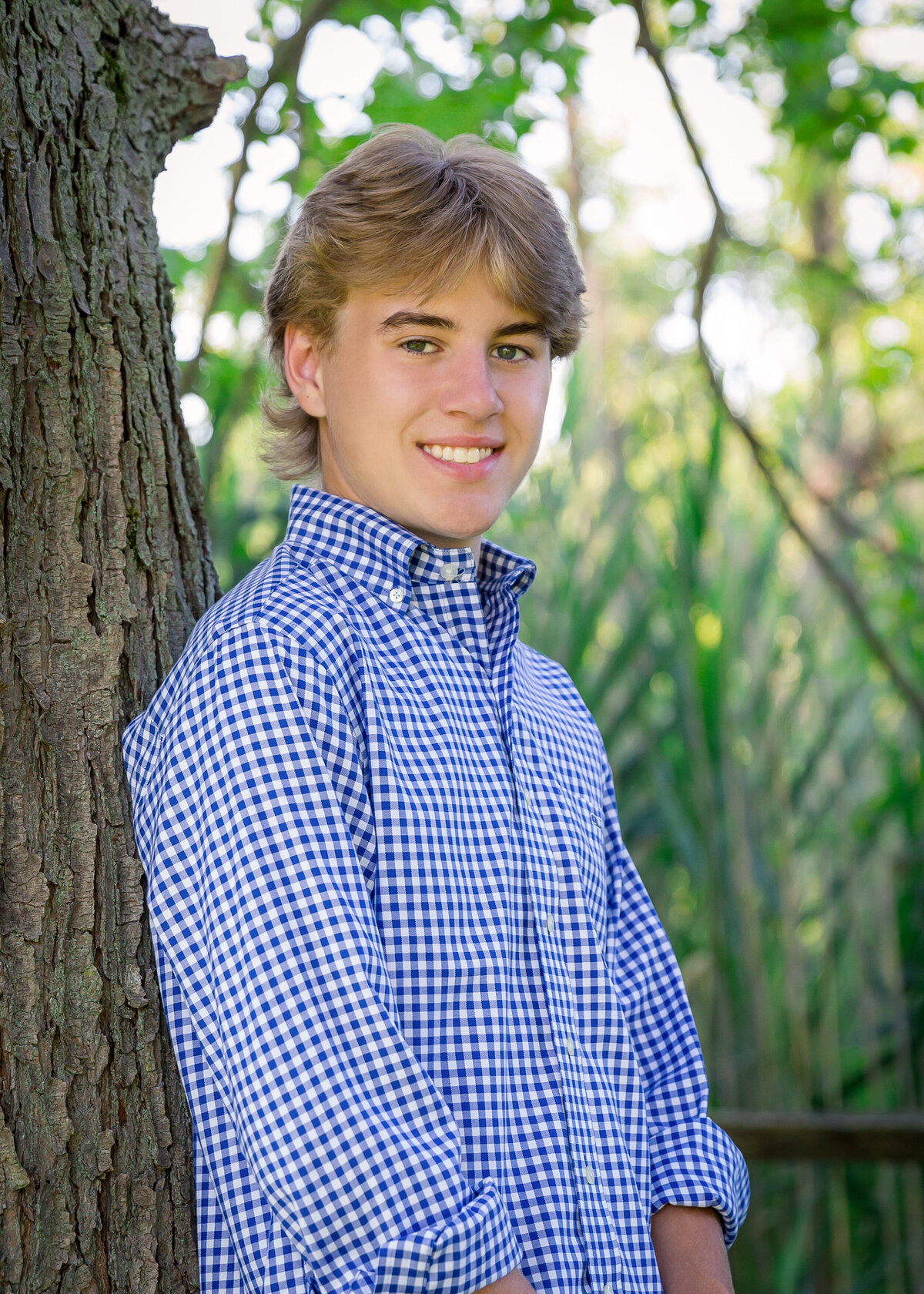 guy leaning on a tree for his senior pictures
