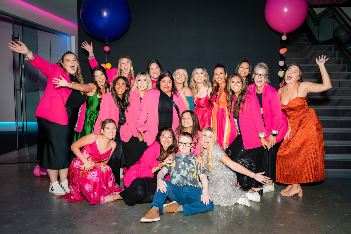 The Intertwined team cheering and throwing balloons for a team photo for RAD Camp.