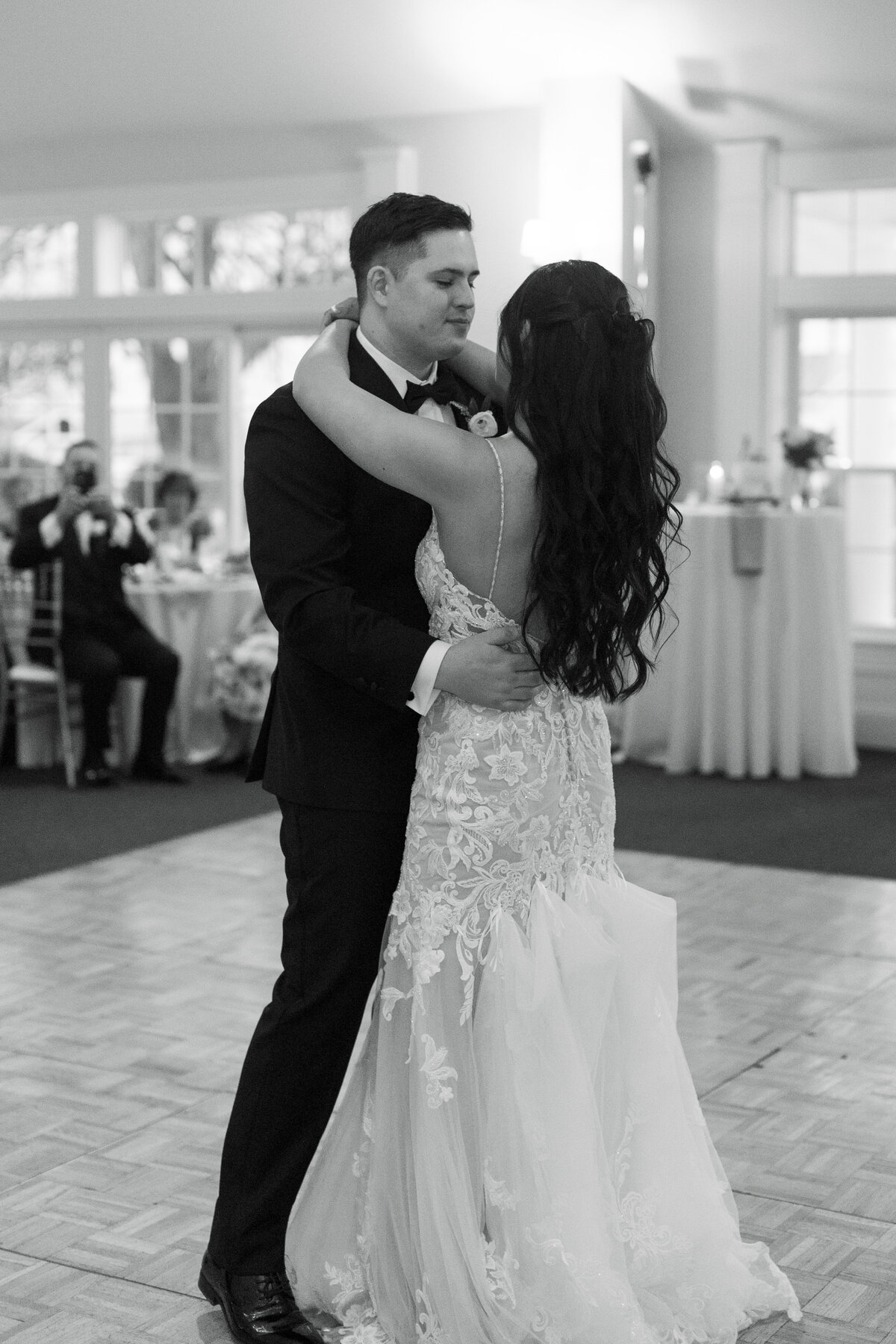Couple sharing romantic first dance during Springfield Manor wedding reception with chandeliers overhead.