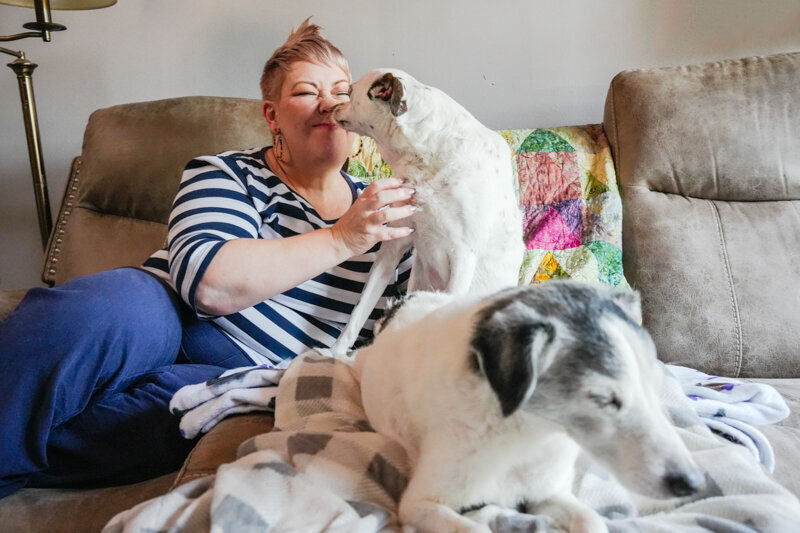 Kirsty Shelley at home on the coach with her two dogs