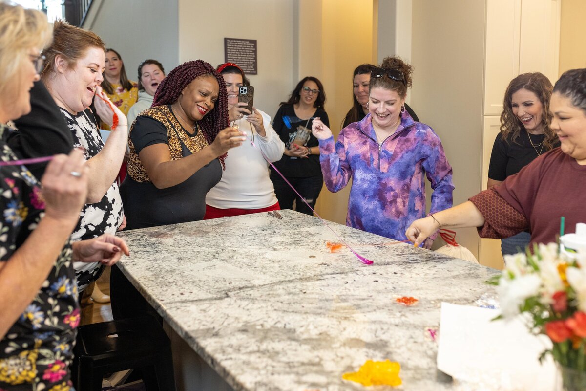 group of women playing game with stick hands at table
