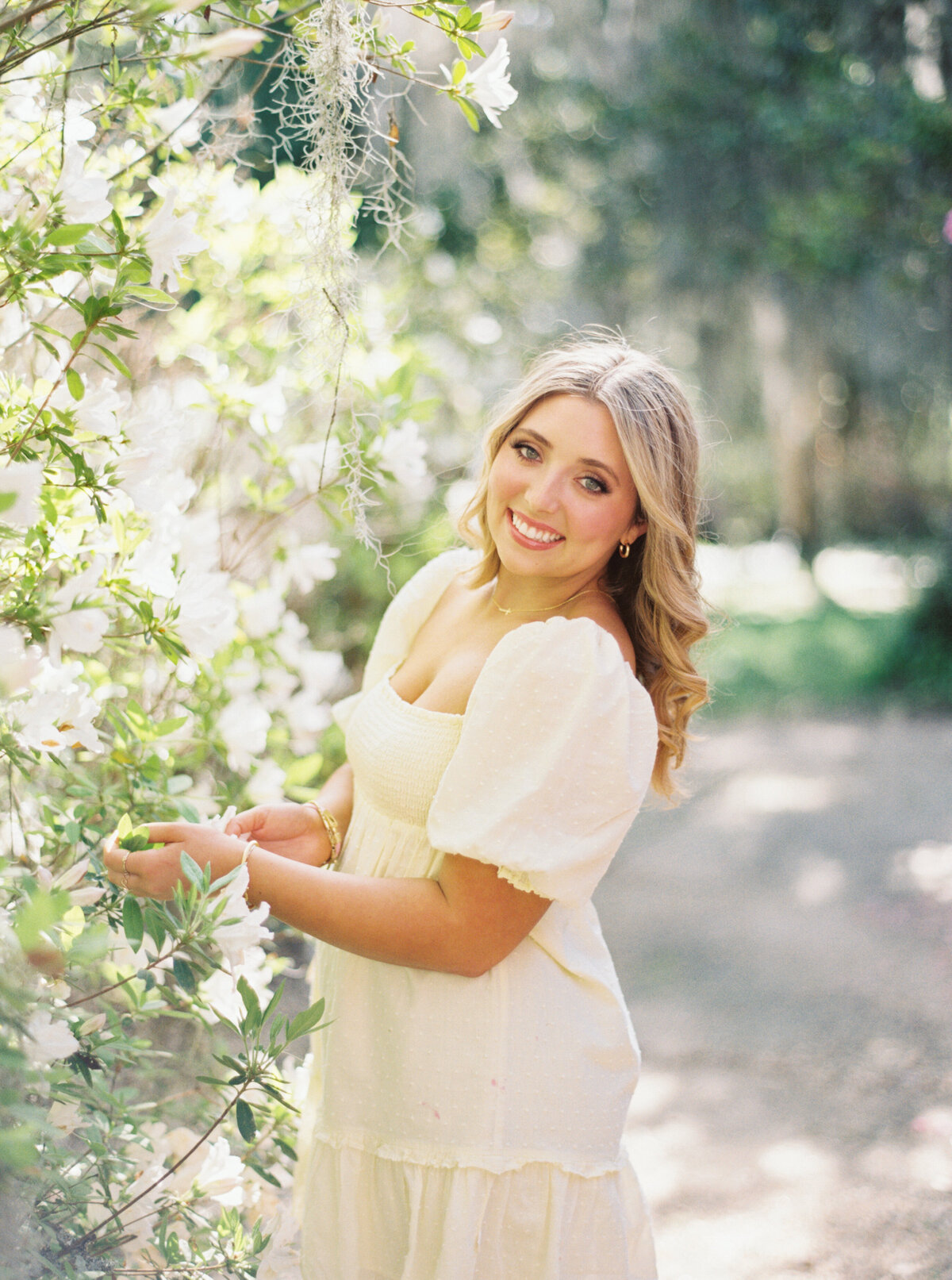 A senior portrait in the lush gardens of Rosedown Plantation, showcasing charm and elegance amid beautiful blooms, captured on film by Morgan Alysse, Louisiana film photographer.
