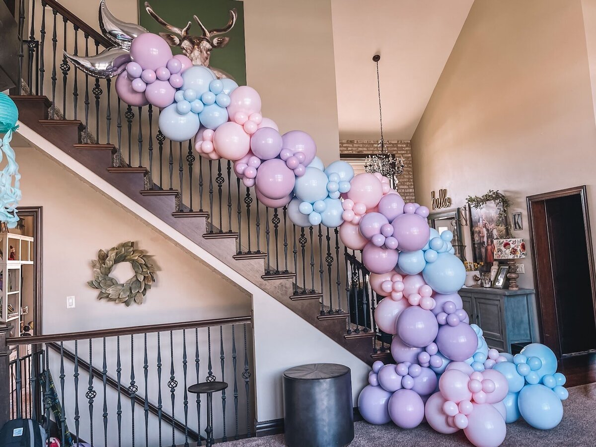 Purple, pink, and blue mermaid themed balloon display on a staircase