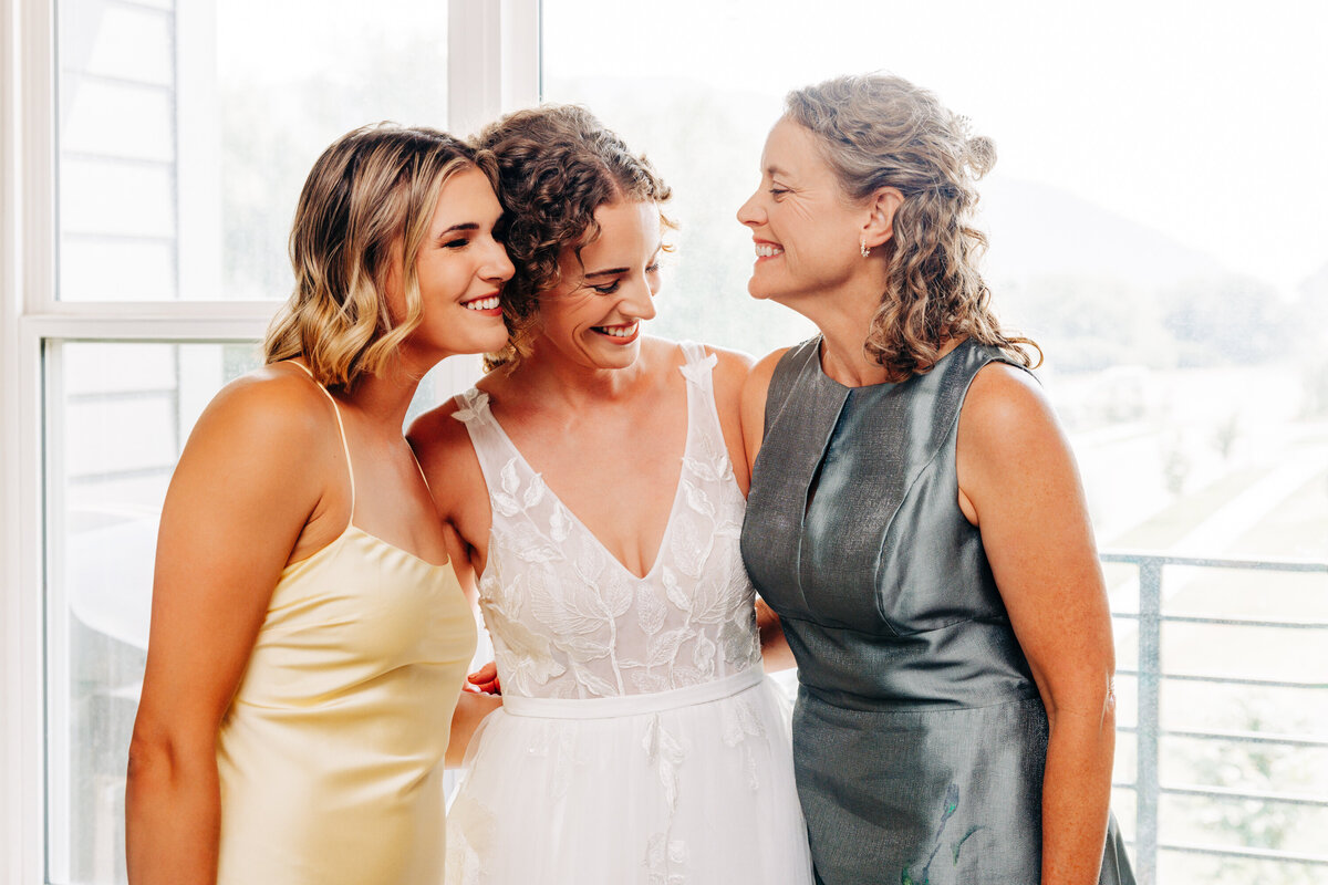 Bride smiling with mother and maid of honor