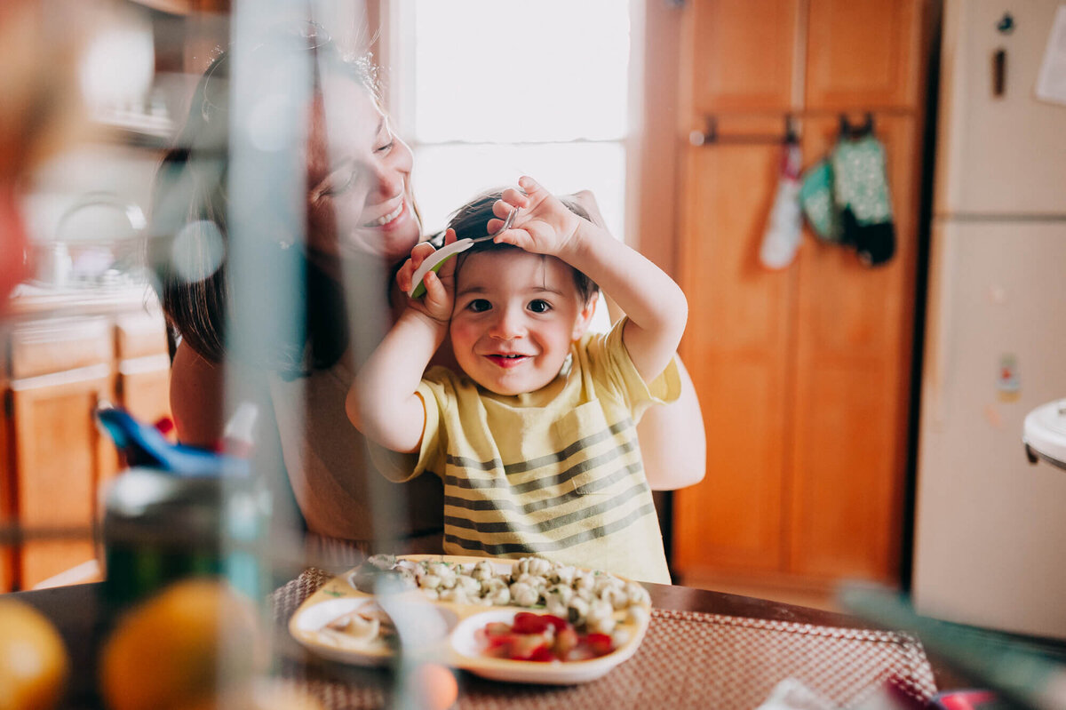 A mother and her young toddler having lunch in their bright kitchen
