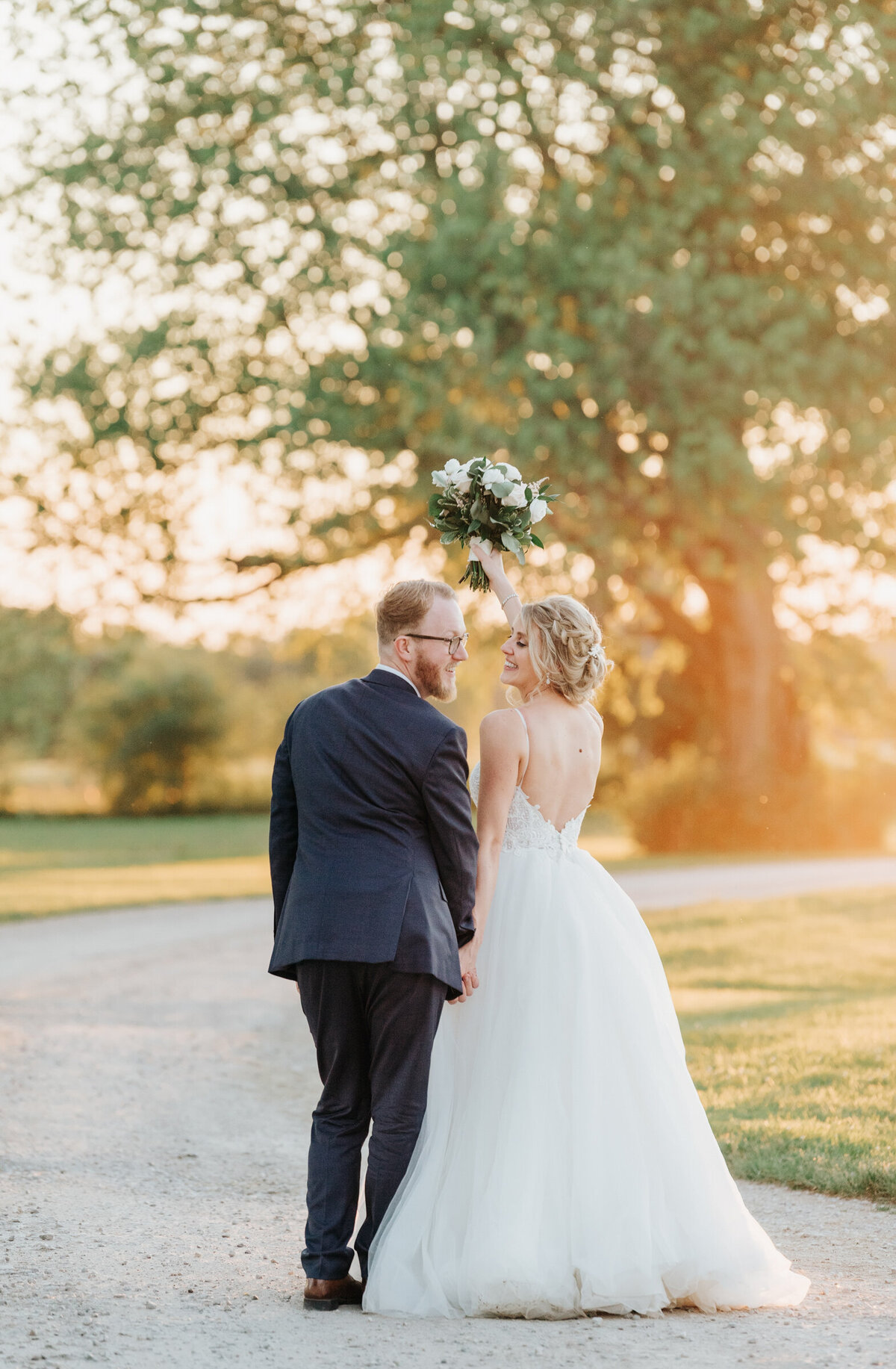 Bride and groom celebrate during sunset wedding portraits