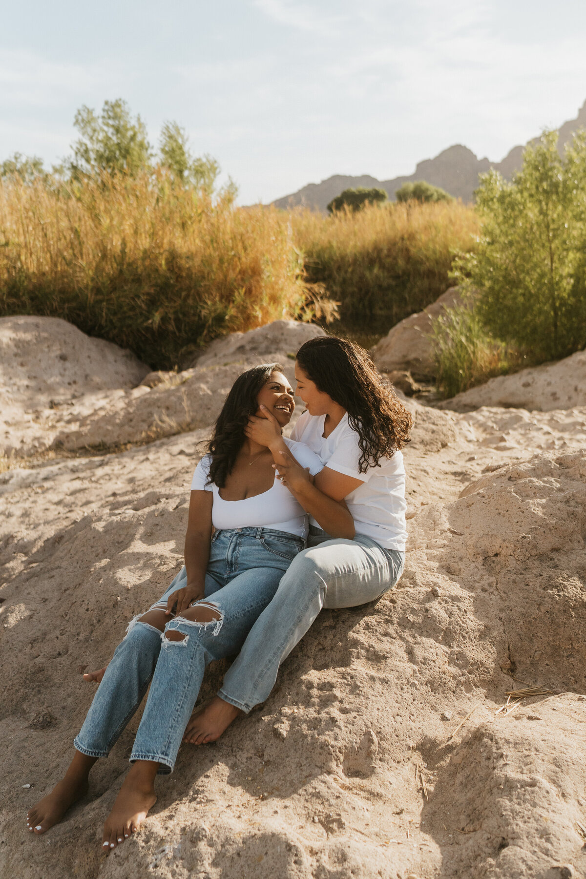 A person sitting behind their partner as they lean in to kiss them 