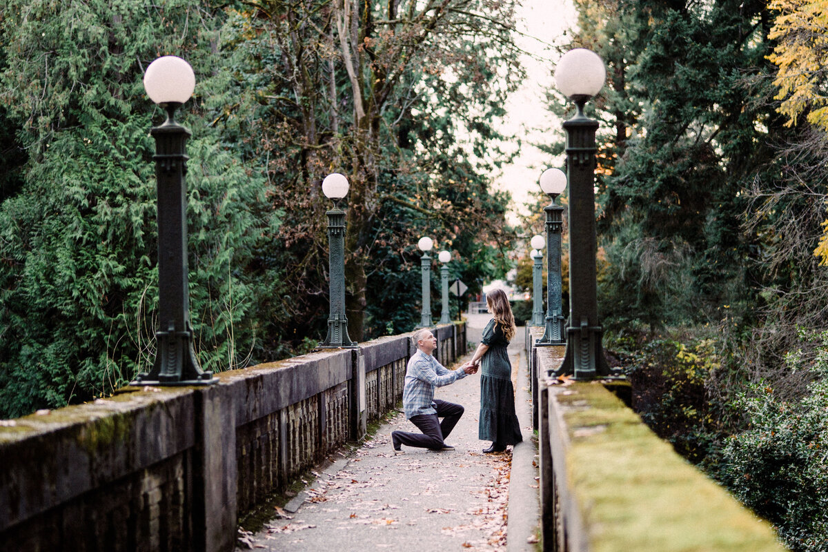 man proposing to girlfriend on stone bridge at university of washington arboretum