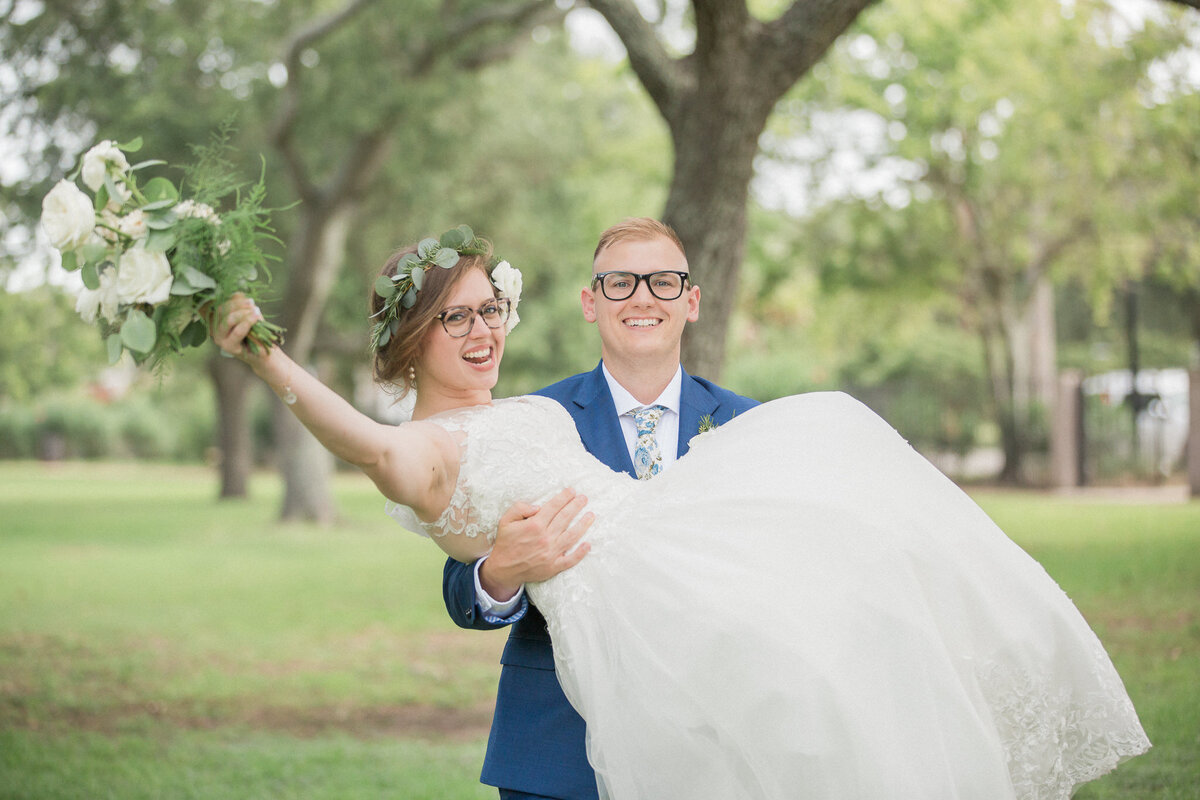The groom hoists his bride in a celebratory moment after the wedding ceremony
