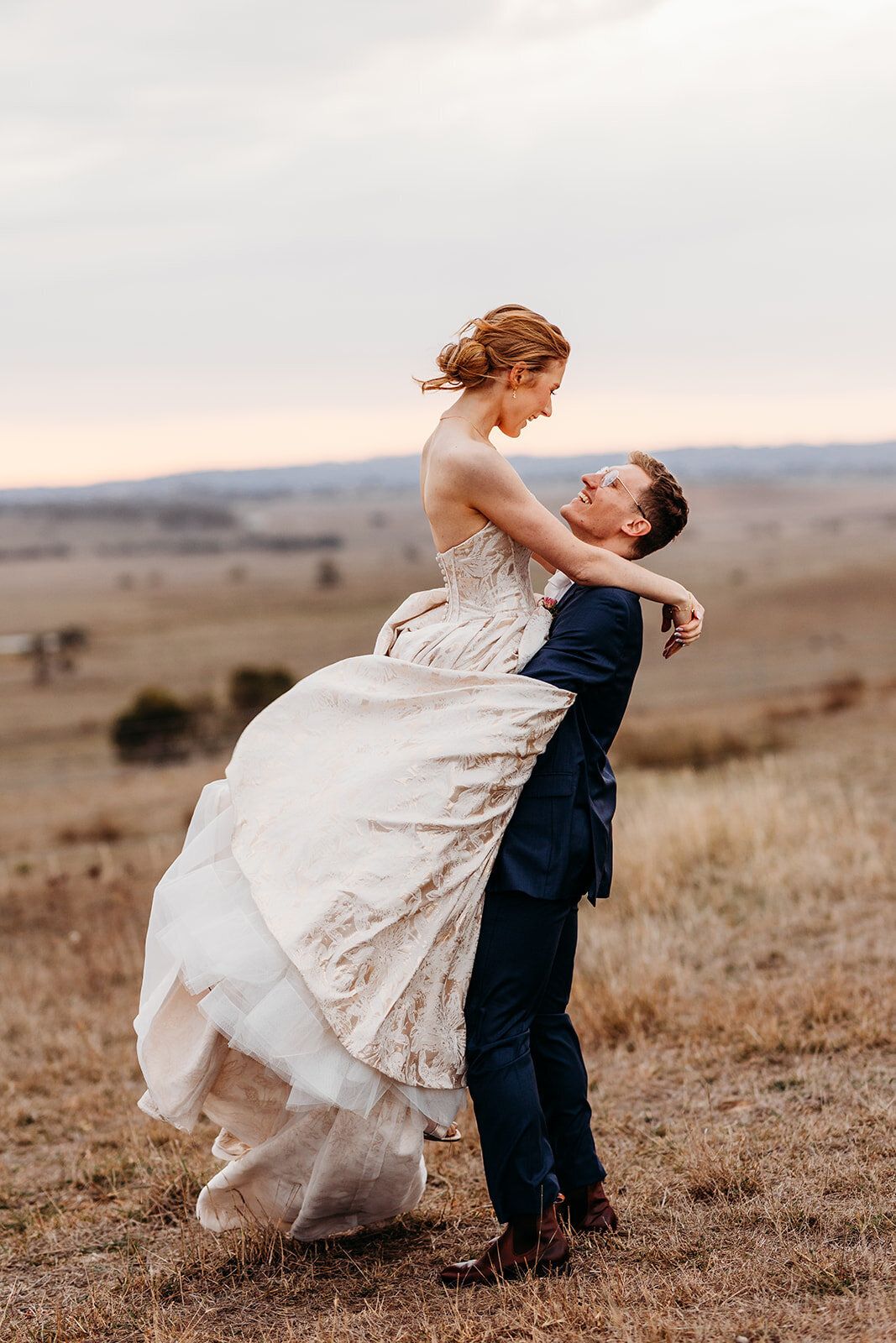 Bride and groom sunset portraits on the hill overlooking Petrichor Farm Gundaroo NSW