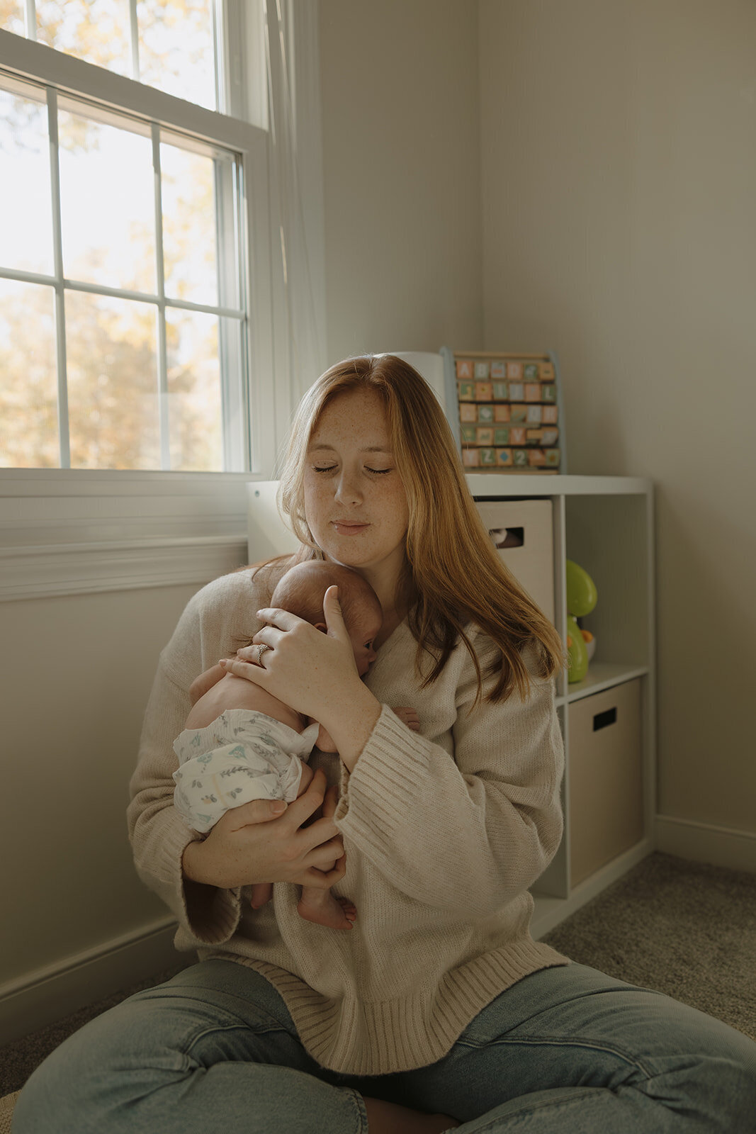 Mom hugging newborn in nursery during photoshoot with RVA newborn photographer