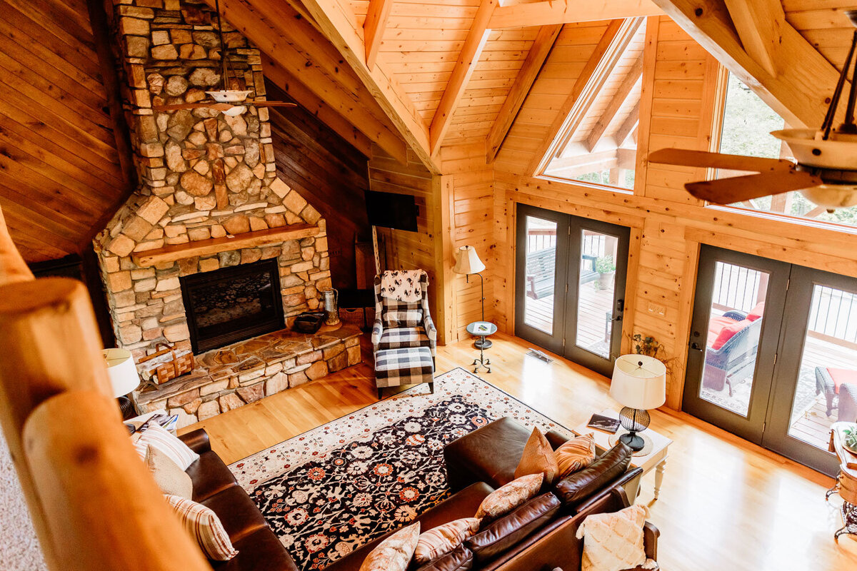 Rustic living room with stone fireplace and vaulted wood ceiling