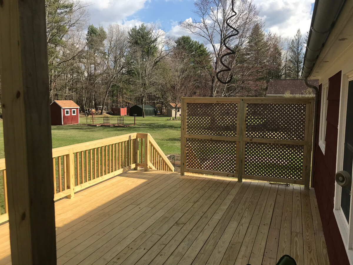 A Pressure treated wood deck including a privacy fence trellis