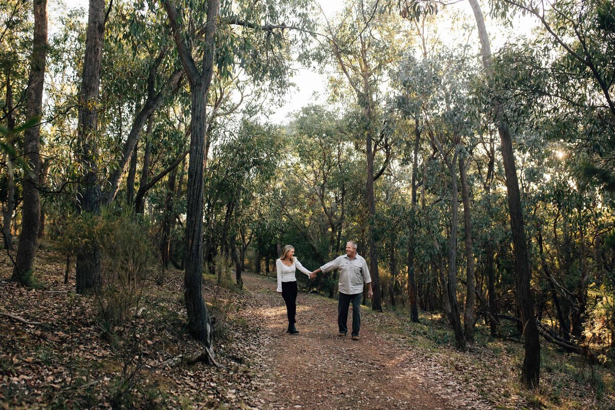 Mature couple holding hands as they walk down a bush lane, couples photoshoot Melbourne, And So I Don't Forget Photography