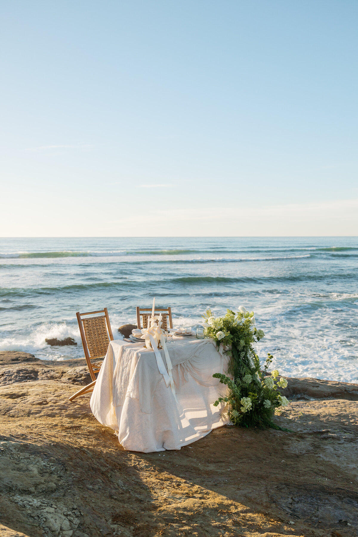 Elegant tablescape featuring lush florals and candles, creating a romantic ambiance for their La Jolla California reception.