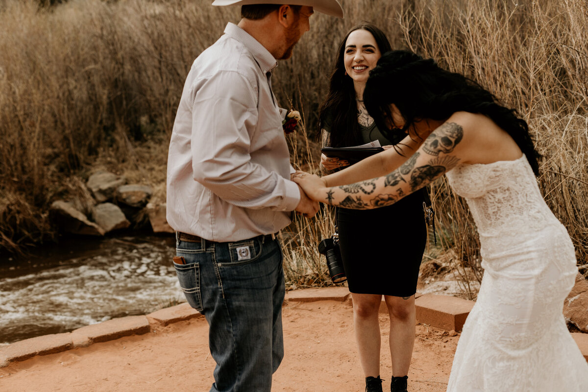 Bride and groom exchanging vows in front of the Jemez Springs red rocks