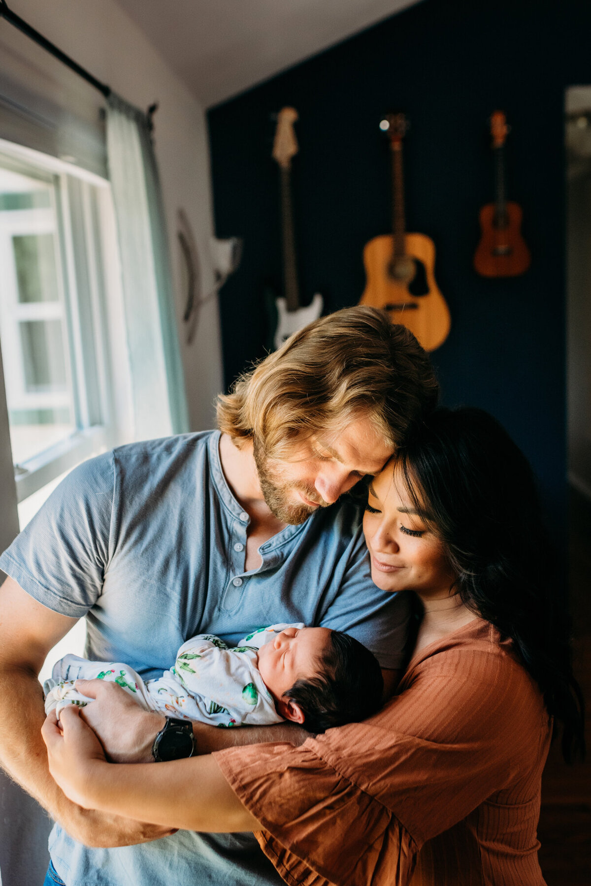 Newborn Photographer, Mom and dad snuggling and looking at baby girl.