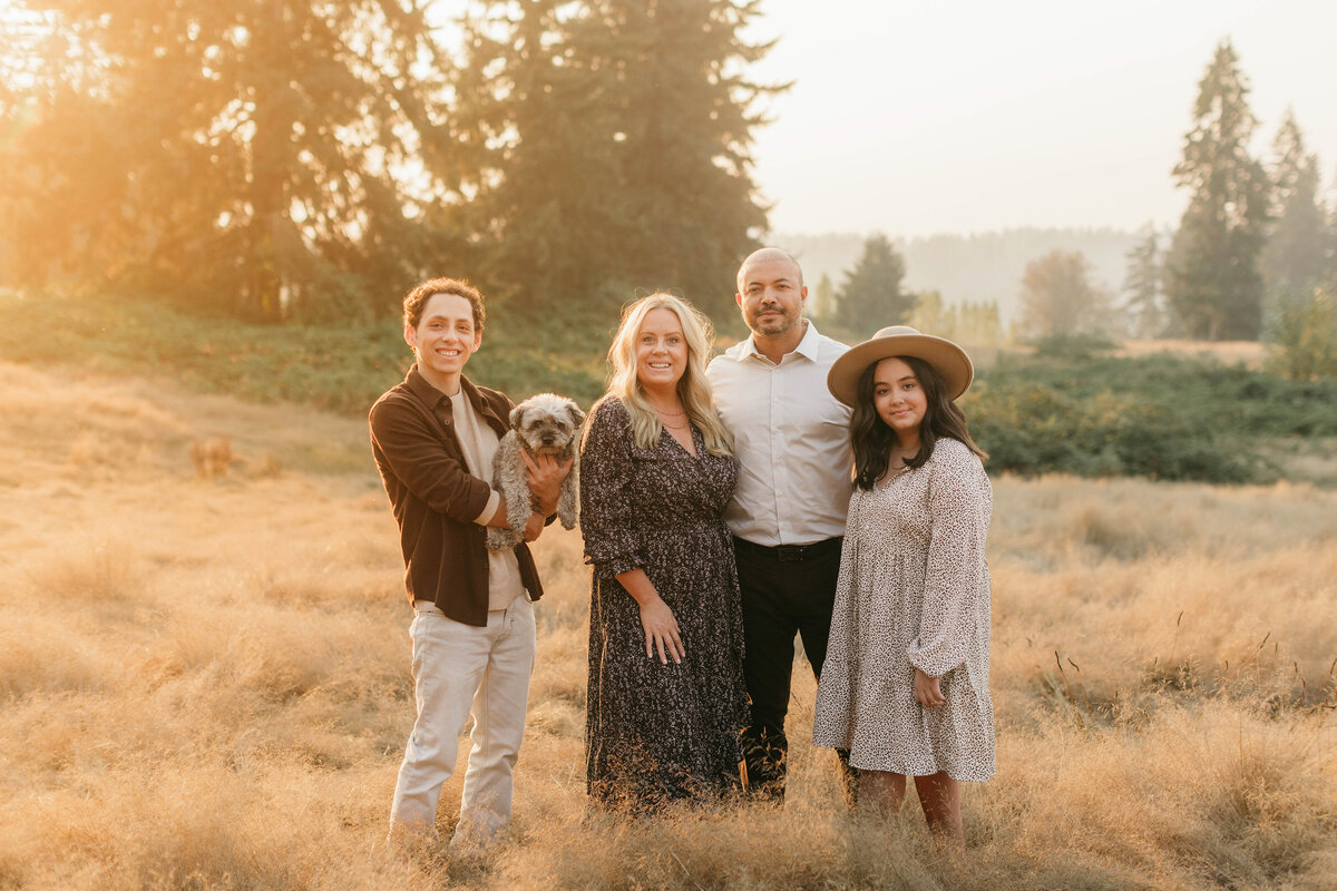 Gorgeous family in a golden field with teen children and pup