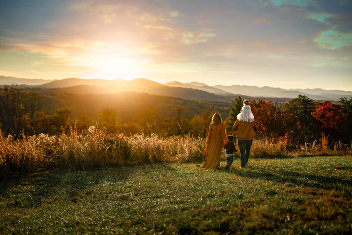 A family strolling on a mountain top at sunset during the fall