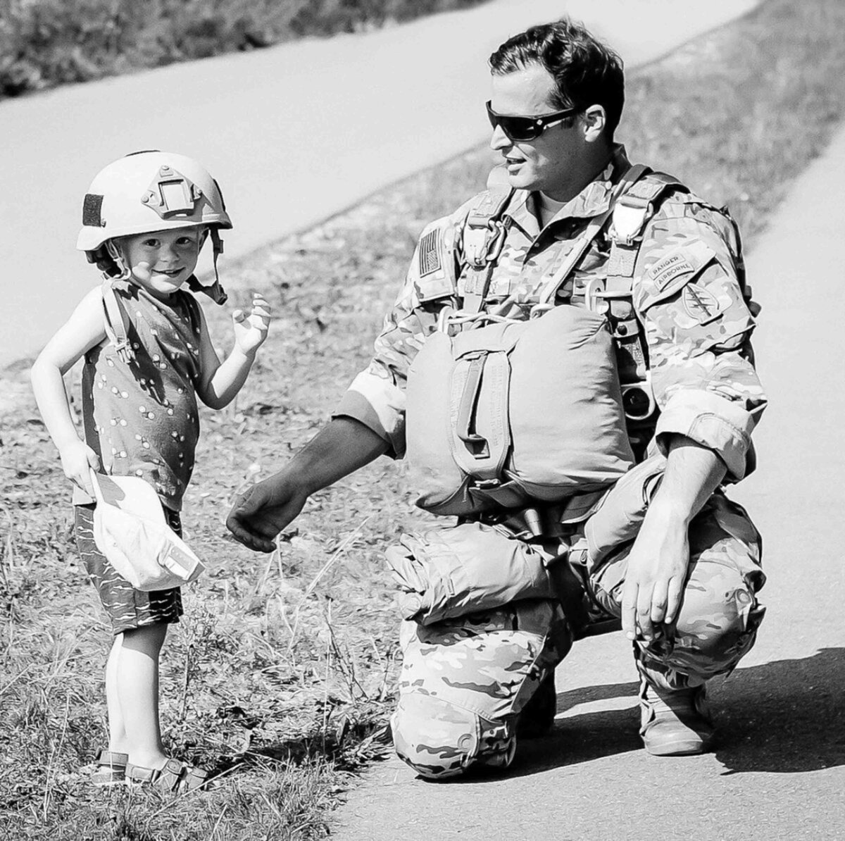 little boy wearing soldier father's combat hat
