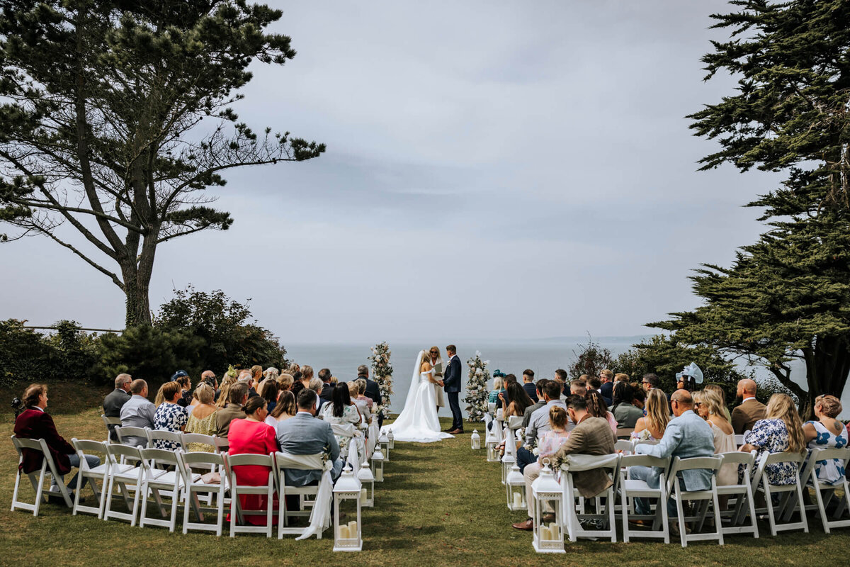 A couple getting married at their wedding ceremony with the sea in the background
