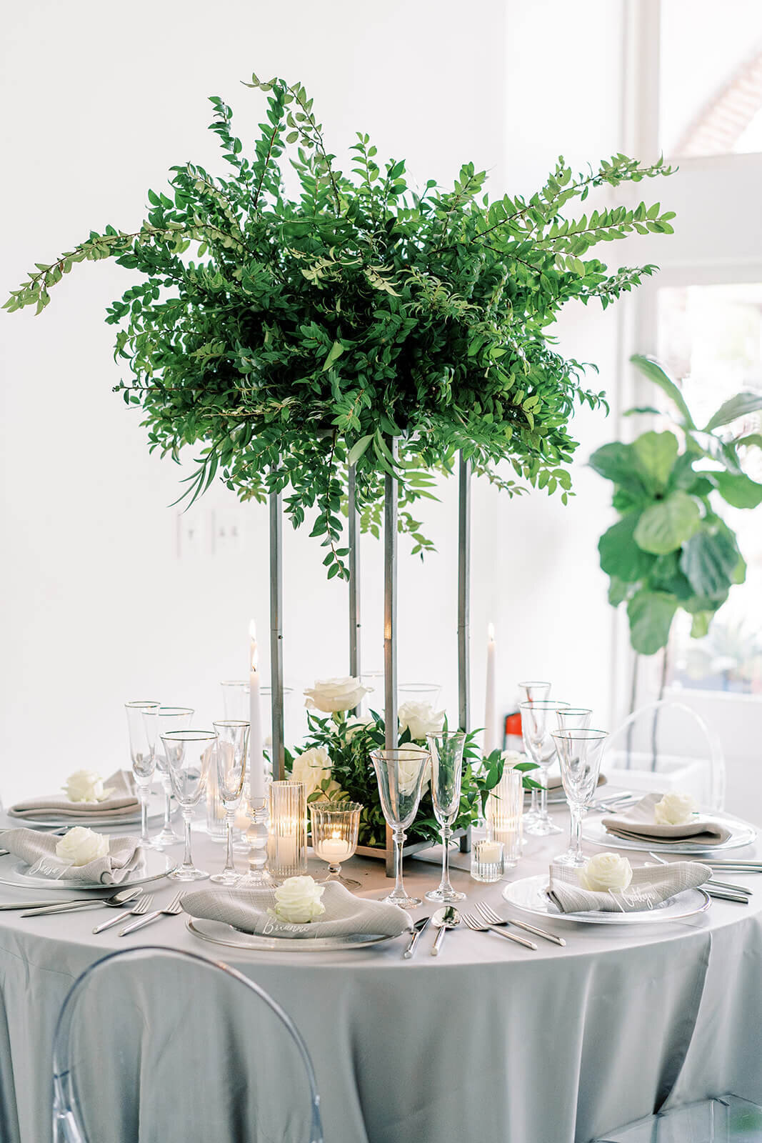 all-greenery-huckleberry-elevated-wedding-centerpiece-on-a-blue-tablelinen