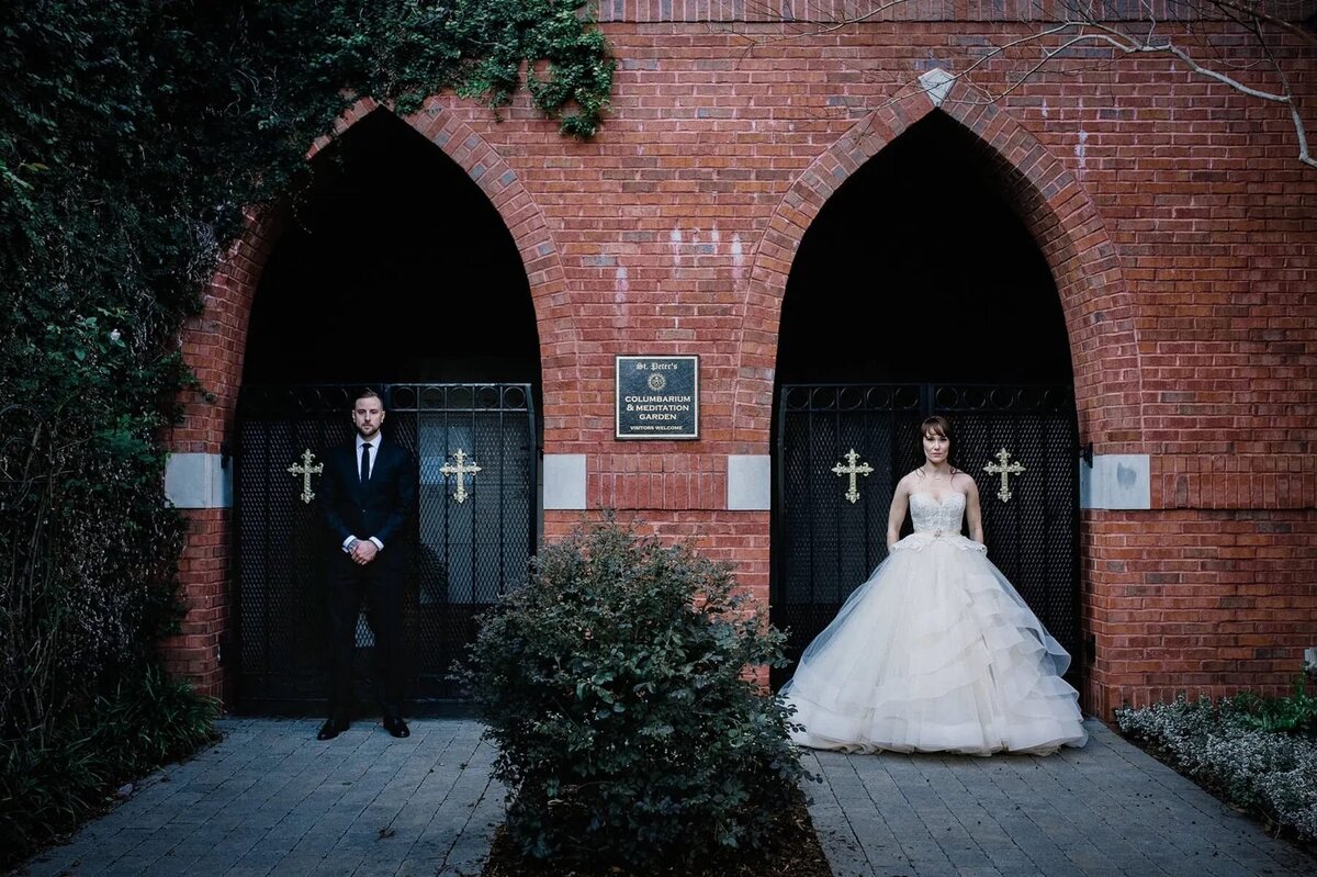 A bride and groom standing in arch ways next to each other.